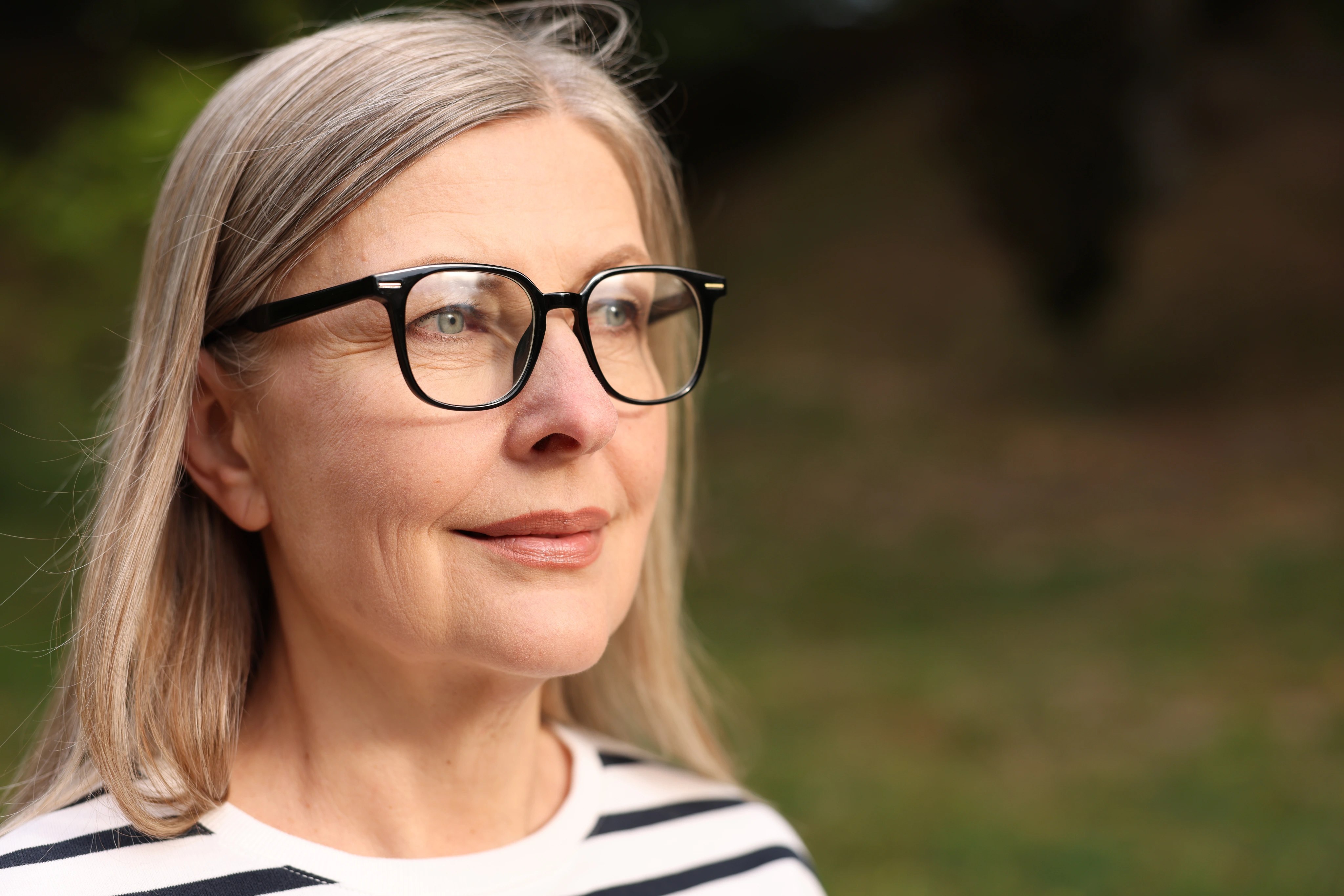 Mujer de cabello gris con anteojos al aire libre