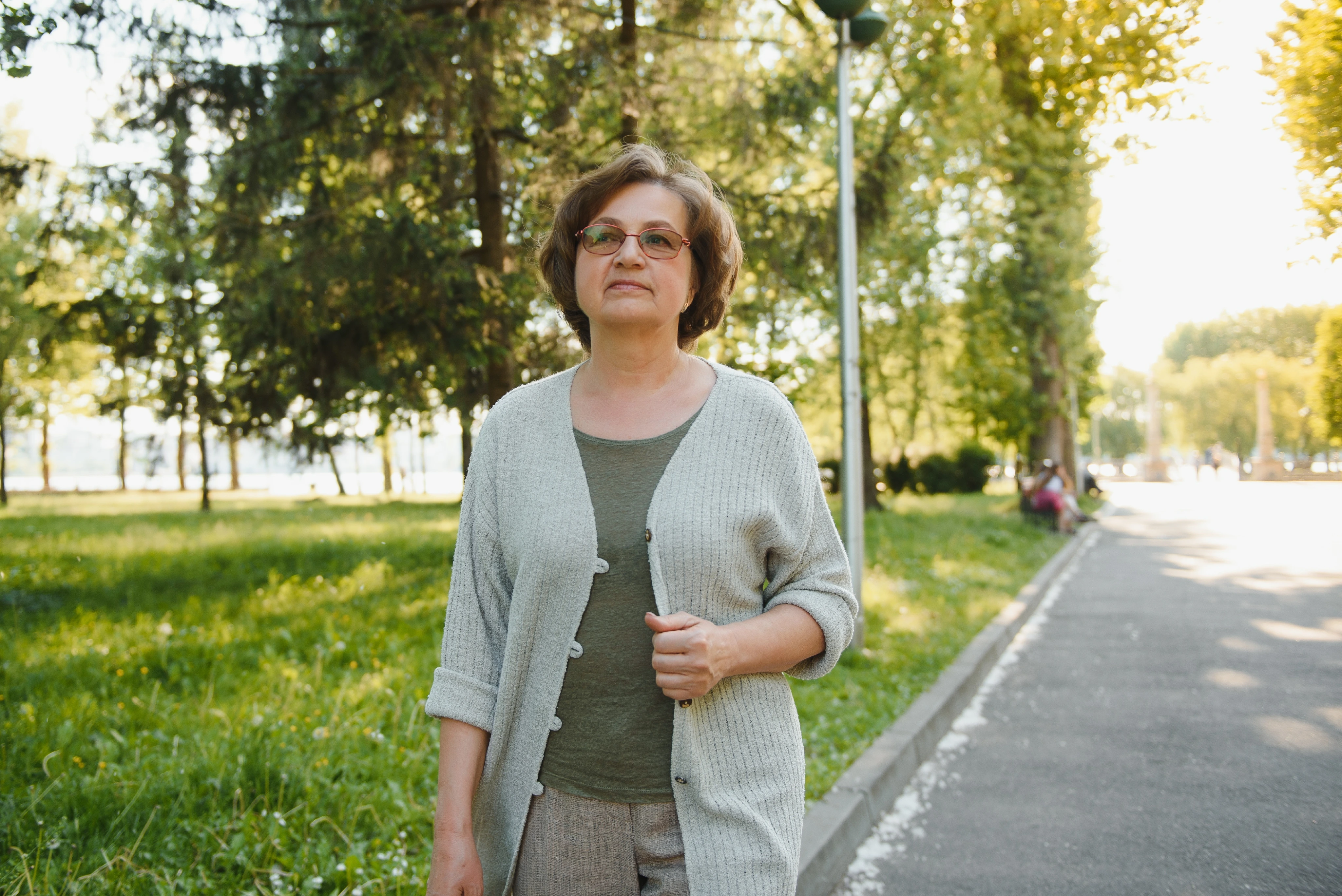 Mujer con anteojos caminando por un parque