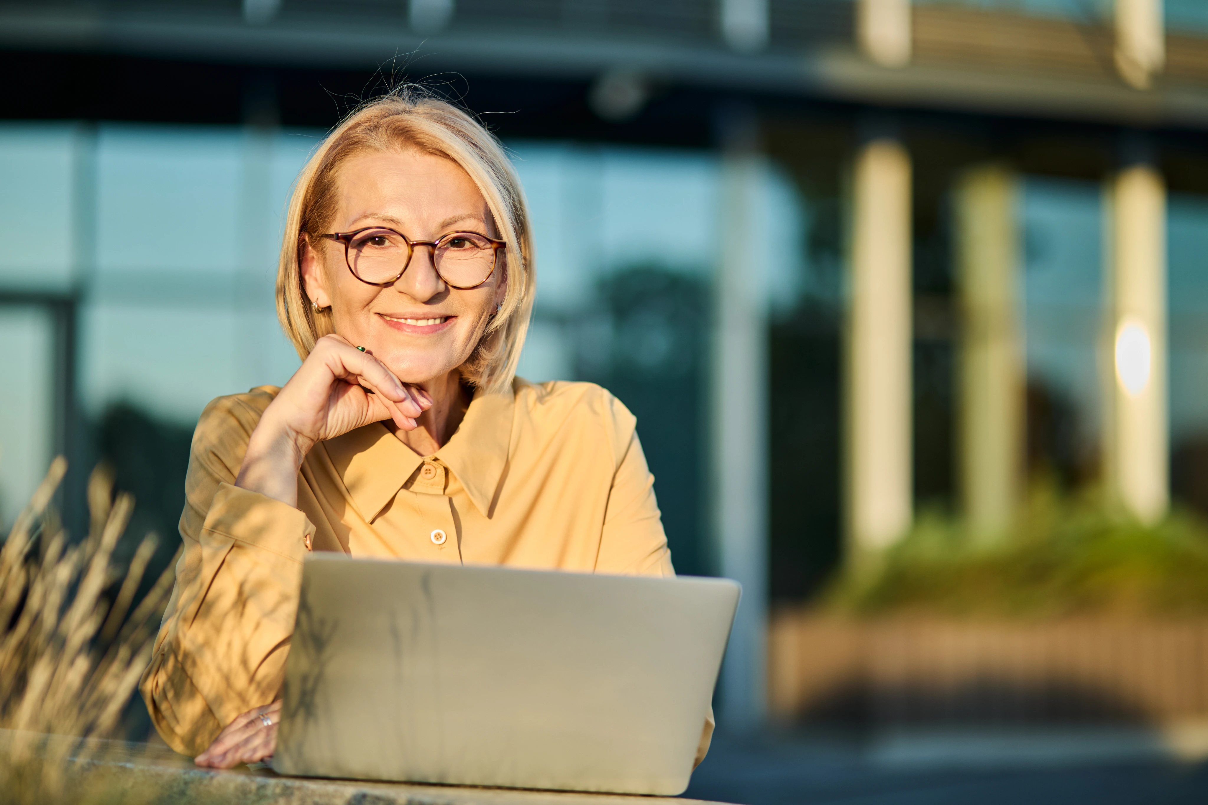 Mujer con anteojos sonriendo al aire libre